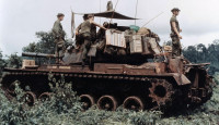 Men of Troop B, 1st Squadron, 10th Cavalry Regiment, 4th Infantry Division, and their M48 Patton tank move through the jungle in the Central Highlands of Vietnam, June 1969.jpg